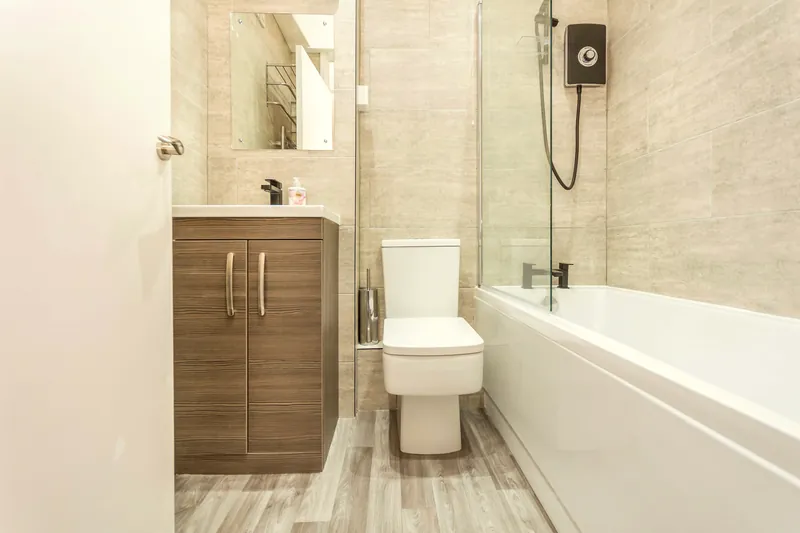 The bathroom — stone-tiled, with a deep bath and fresh towels