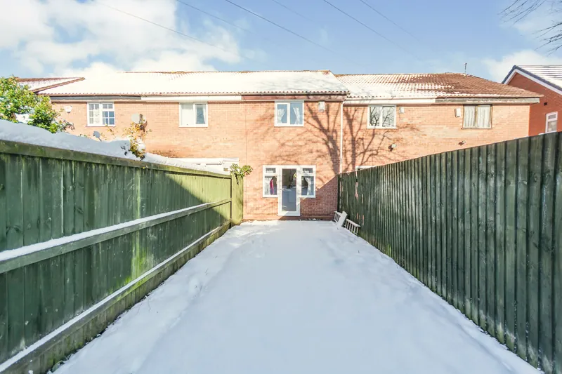 The garden in winter — a private, fenced stretch of snow-dusted lawn